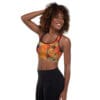 A woman is posing for the camera wearing black pants and a sports bra.