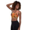 A woman is posing for the camera wearing black pants and a sports bra.