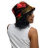 A woman wearing a hat with red and green flowers.
