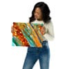 A woman holding up an abstract painting.