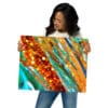 A woman holding up an abstract painting.