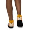 A person wearing black and yellow shoes with white soles.