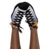 A person wearing sneakers with black laces.