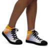 A person wearing black shoes with white and orange design