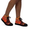 A person wearing black shoes with orange and red design.