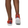 A person wearing orange shoes with white soles