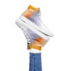 A person wearing white sneakers and jeans.