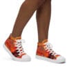 A person wearing orange and white shoes with floral designs.
