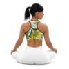 A woman sitting in the lotus position wearing a sports bra.