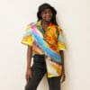 Woman in vibrant abstract print shirt.