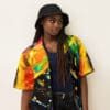 Woman in colorful shirt and black hat.