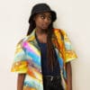 Woman in colorful shirt and bucket hat.