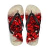 A pair of flip flops with red and white flowers on them.