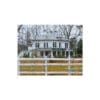 White farmhouse behind a white fence.