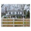 White farmhouse behind a fence.