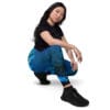 Woman in blue nebula leggings squatting.