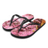 A pair of flip flops with pink flowers on them.