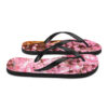 A pair of flip flops with pink flowers on them.