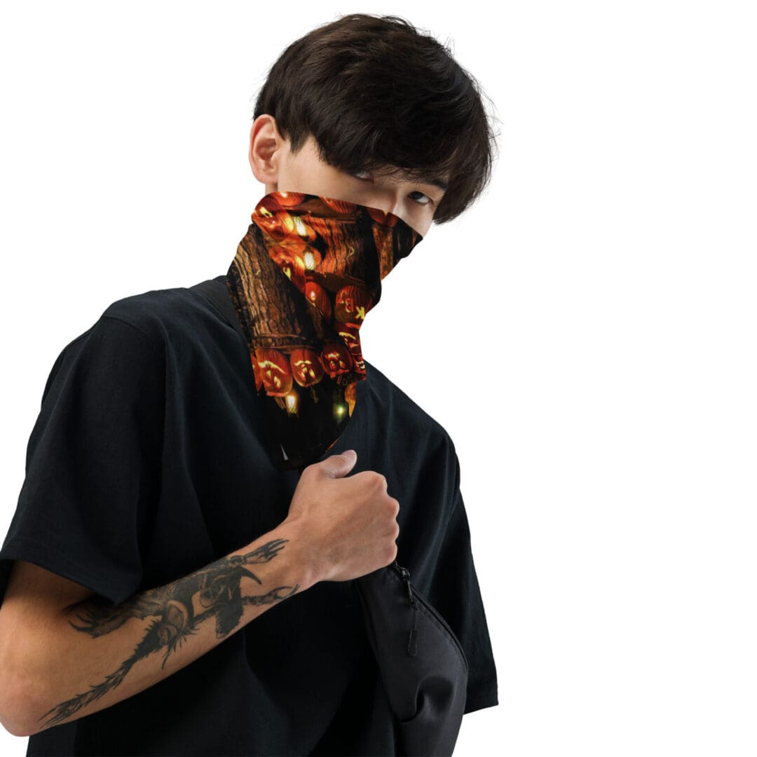 Person wearing Halloween-themed neck gaiter, tattoo visible.
